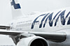 Close-up of a Finnair passenger jet fuselage and engine on an airport apron.