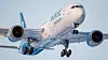 Norse Atlantic Airways passenger jet viewed from below against a pale blue sky