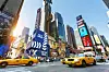 Times Square i New York med gula taxibilar, höga reklamskyltar och tät stadstrafik.