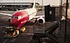 Norwegian-flygplan parkerat vid gate med flygplatsfordon framför nosen.