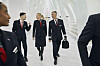 Fyra Norwegian-anställda i uniform går genom en ljus flygplatsterminal.