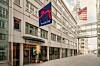 Tom stadsgata mellan kontorsbyggnader med en synlig Santander Consumer-skylt.