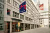 Tom stadsgata mellan kontorsbyggnader med en synlig Santander Consumer-skylt.