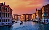 En kanal i Venedig med båtar mellan gamla byggnader i kvällsljus.
