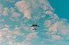 **A small airplane is seen against a cloudy blue sky.**