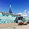 Glasad hotellbyggnad med stor skylt som säger Good Morning Hotels mot blå himmel.