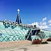 Glasad hotellbyggnad med stor skylt som säger Good Morning Hotels mot blå himmel.