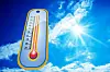 En termometer mot blå himmel och solsken som visar hög temperatur.