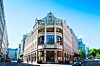 Ett stort historiskt hotell med ljus fasad och skylt mot gatan i centrala Oslo.