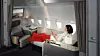 En passagerare sitter i en privat förstaklassvit ombord på ett flygplan.