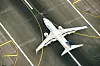 Ett vitt United Airlines-passagerarflygplan taxar på en flygplats, sett ovanifrån.