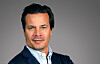 Portrait of Mathias Hedlund, chief executive of Etraveli Group, wearing a navy jacket against a grey background.