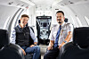 Markus Olsson and Mattias Eriksson seated inside a bright private aircraft cabin.