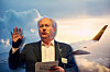 Didrik von Seth gestures beside an aircraft image while holding a statement card.
