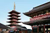 Femvåningspagod och traditionella tempelbyggnader i en japansk tempelmiljö under klarblå himmel.