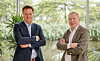 Jeroen de Swart and Lars Löfgren stand with folded arms in a bright, plant-filled office.