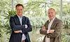 Jeroen de Swart and Lars Löfgren stand with folded arms in a bright, plant-filled office.